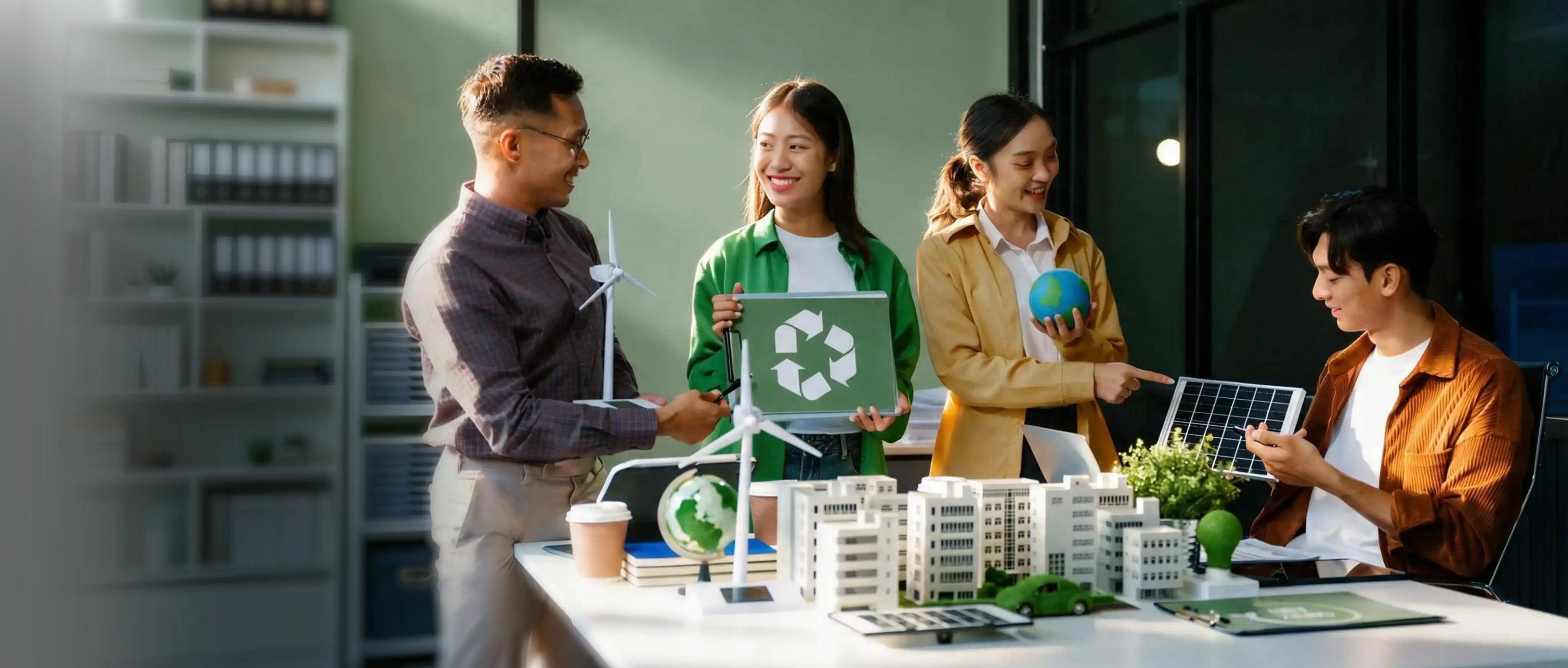 Team discussing sustainability models with wind turbines, solar panel and recycling sign